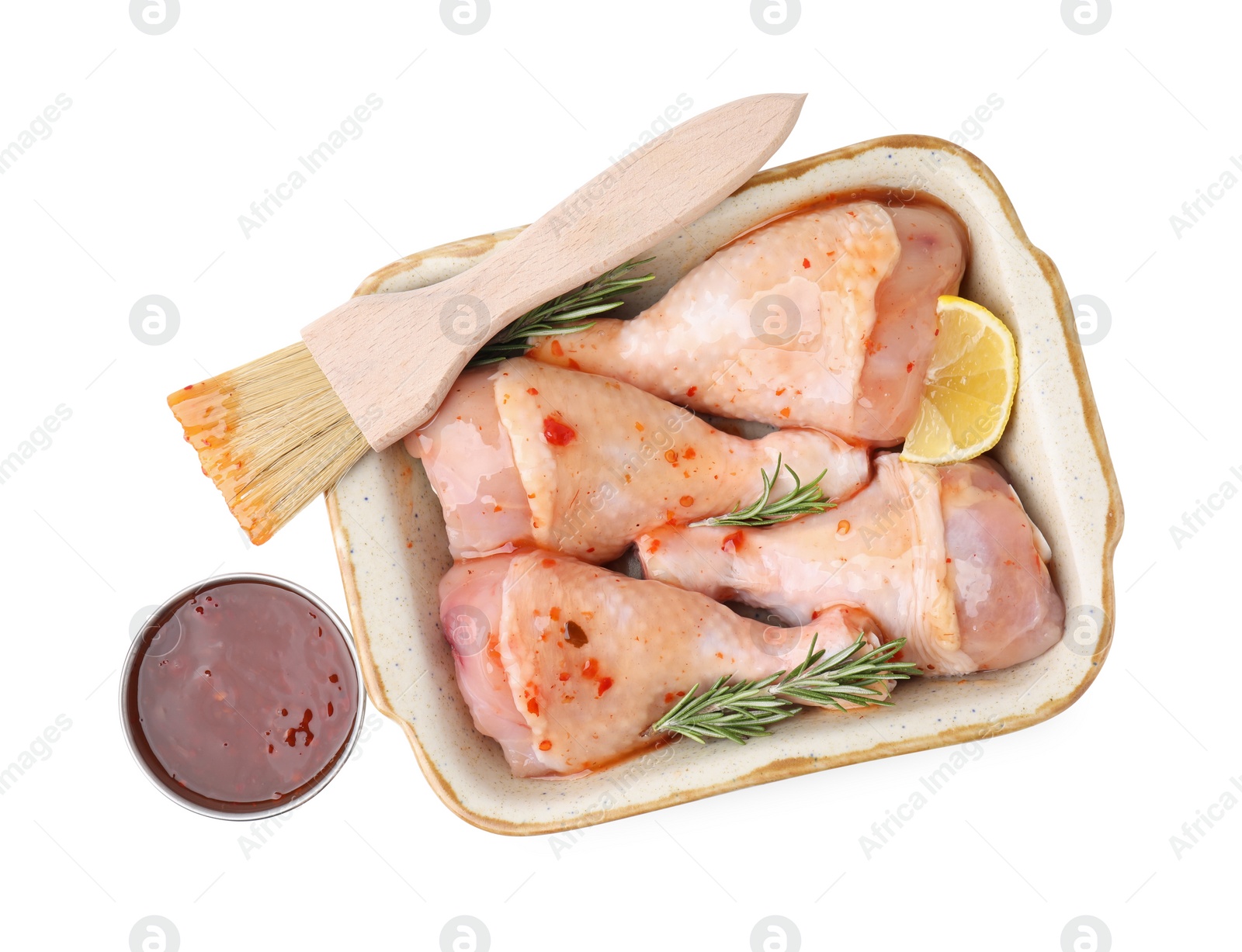 Photo of Fresh marinade, basting brush, raw chicken drumsticks, rosemary and lemon isolated on white, top view