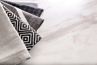 Many soft kitchen towels on white marble table, space for text