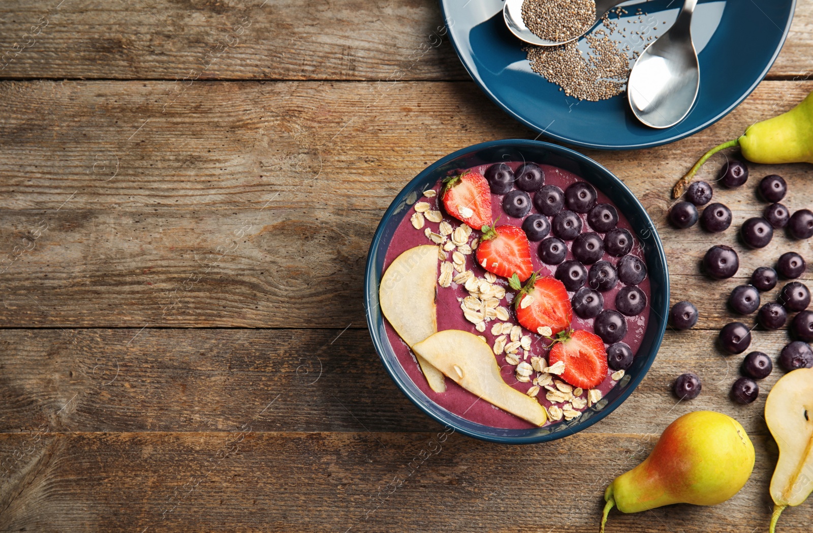 Photo of Flat lay composition with bowl of tasty acai smoothie on wooden table