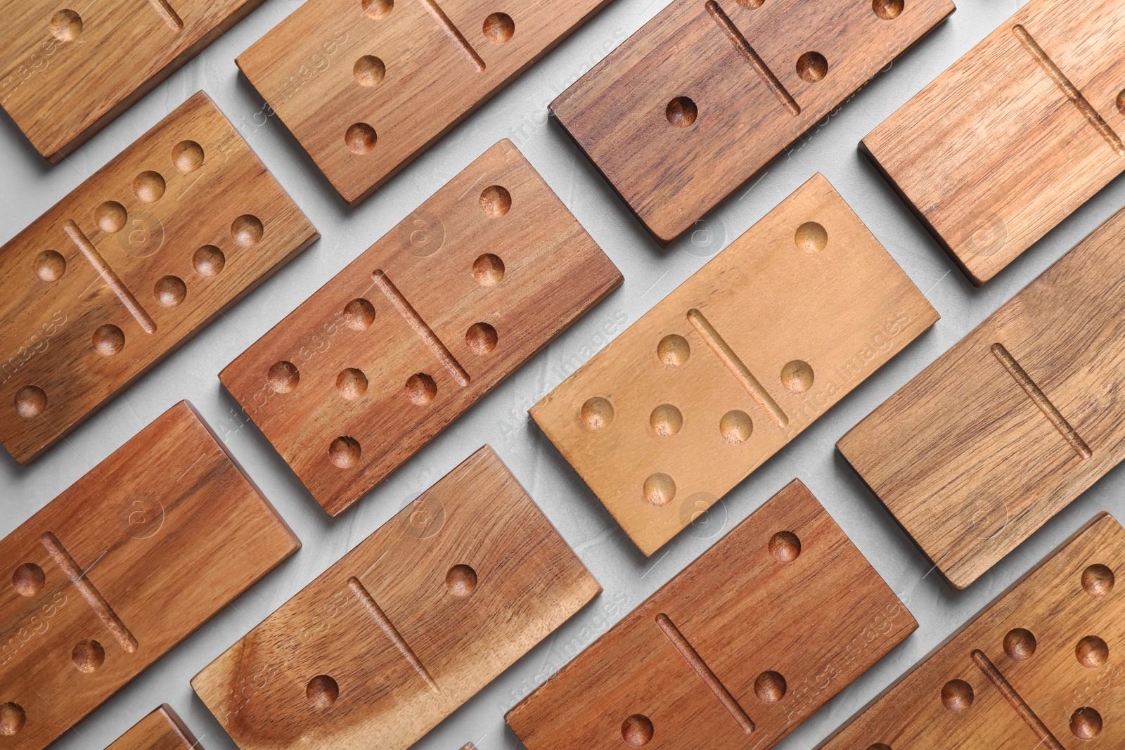 Photo of Set of wooden domino tiles on light grey table, flat lay