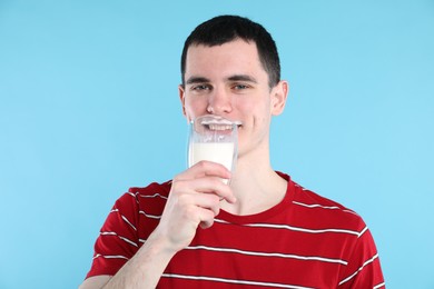 Milk mustache left after dairy product. Man drinking milk on light blue background