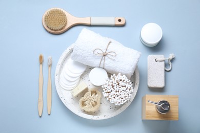Photo of Bath accessories. Flat lay composition with personal care products on light blue background