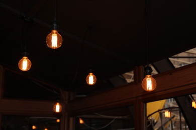 Photo of Glowing lamp bulbs in room. Interior element