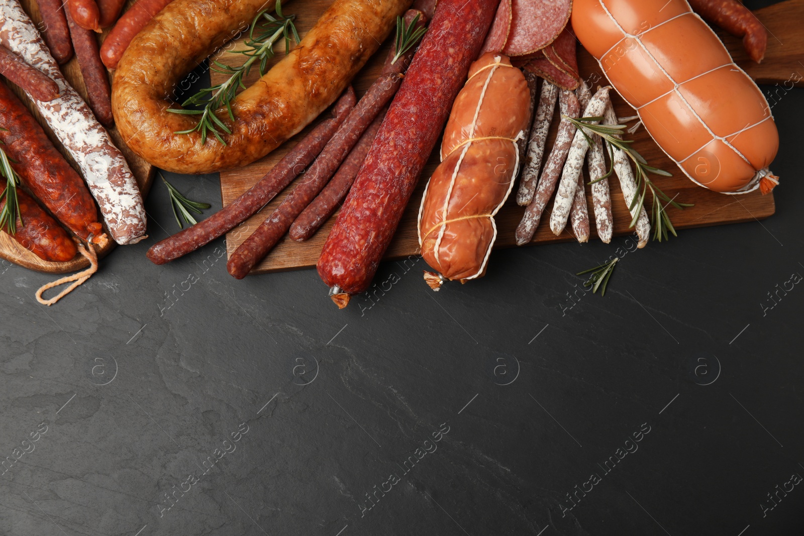 Photo of Different tasty sausages on black table, flat lay. Space for text