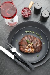 Photo of Tasty grilled beef meat served on black table, flat lay