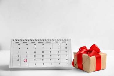 Photo of Paper calendar and gift box on light background. Christmas countdown