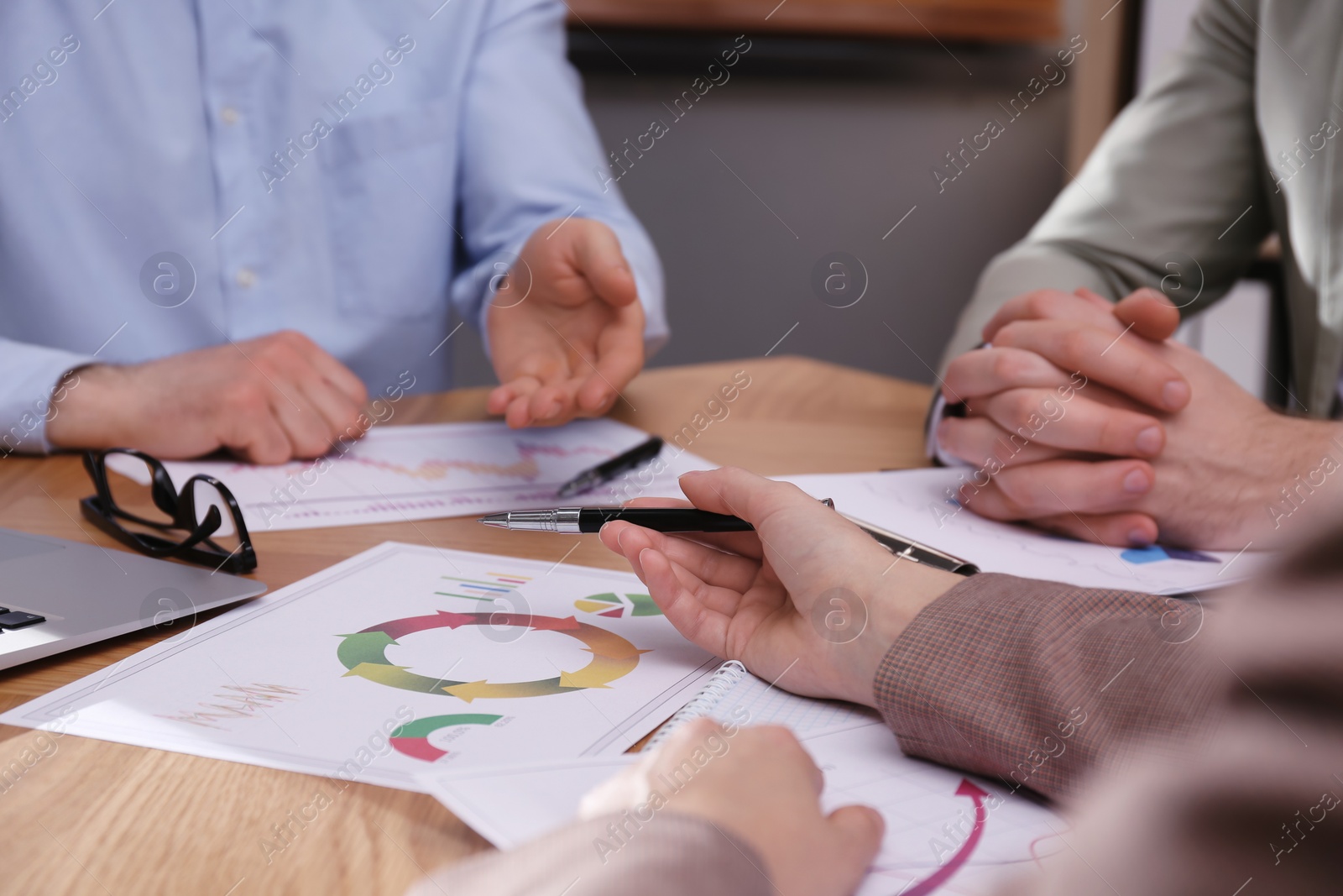 Photo of Business people working with charts and graphs at table in office, closeup. Investment analysis