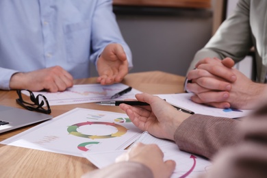 Photo of Business people working with charts and graphs at table in office, closeup. Investment analysis