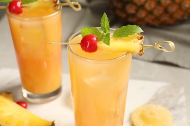 Photo of Tasty pineapple cocktail with mint and cherry on table, closeup