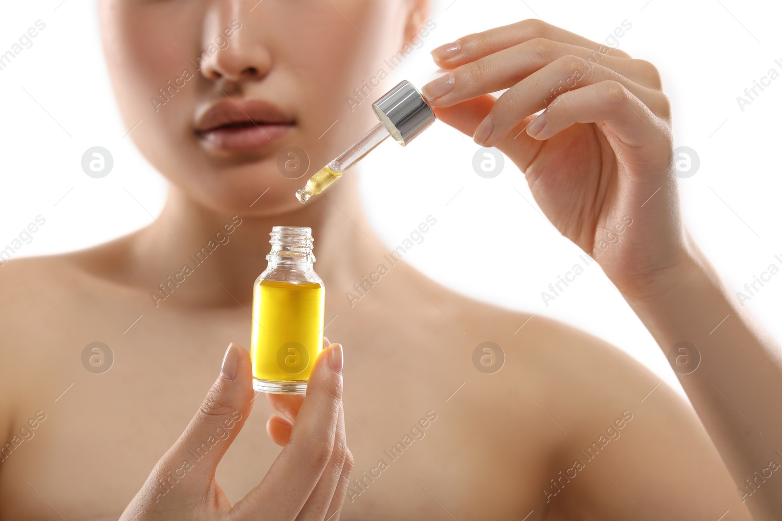 Photo of Beautiful young woman with bottle of cosmetic serum on white background, selective focus