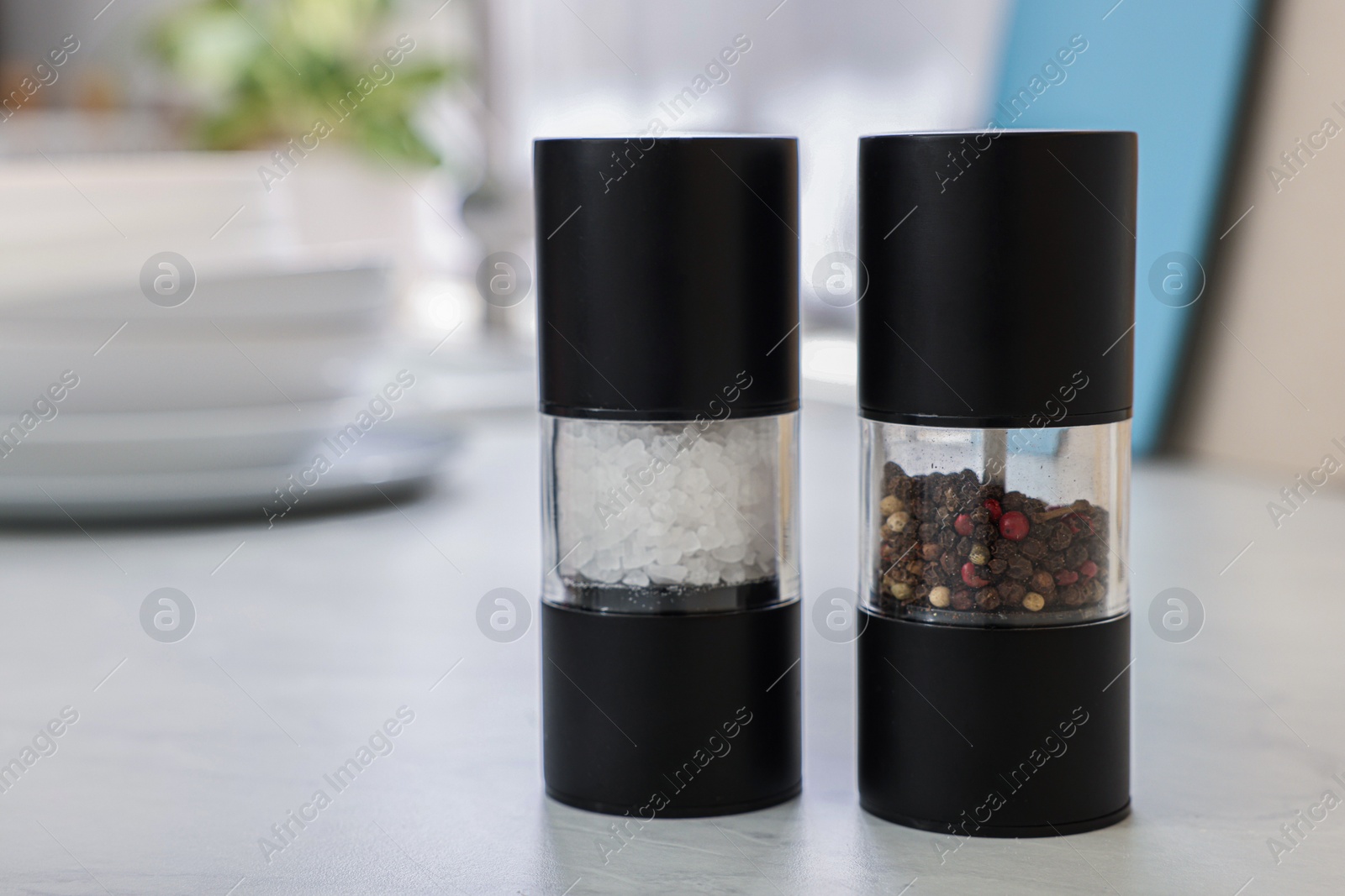 Photo of Salt and pepper shakers on white table, space for text