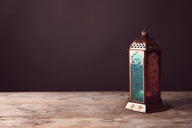 Muslim lamp with candle on wooden table. Fanous as Ramadan symbol