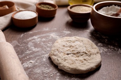 Photo of Fresh dough and rolling pin on wooden table. Cooking grissini
