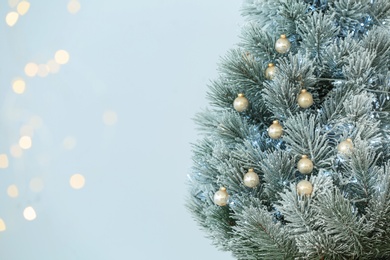 Decorated Christmas tree against blurred festive lights. Space for text