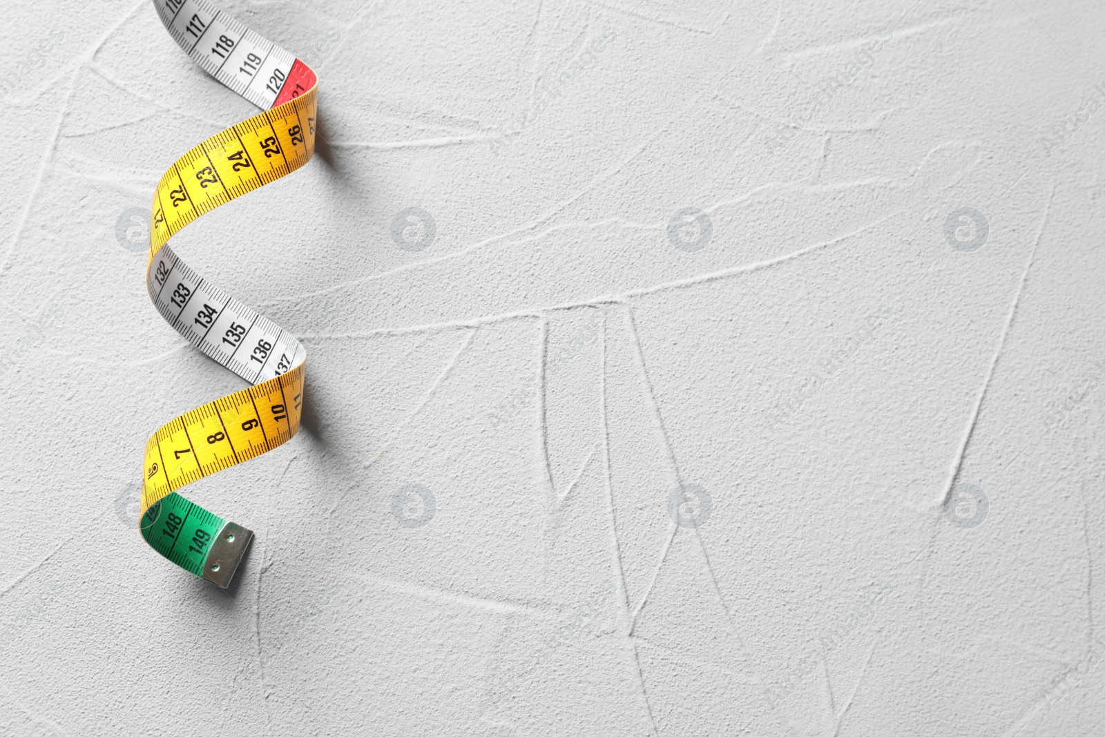 Photo of Measuring tape on grey background, top view. Tailoring equipment