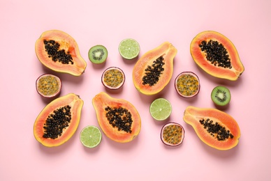 Photo of Fresh ripe papaya and other fruits on pink background, flat lay