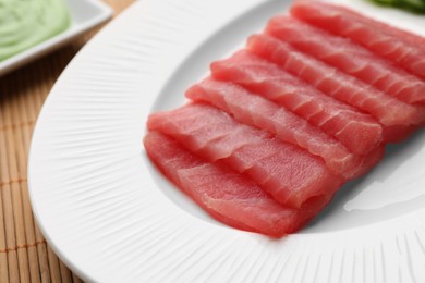 Photo of Tasty sashimi (pieces of fresh raw tuna) on white plate, closeup