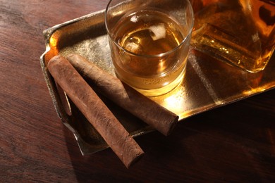 Photo of Tray with cigars and whiskey on wooden table, above view