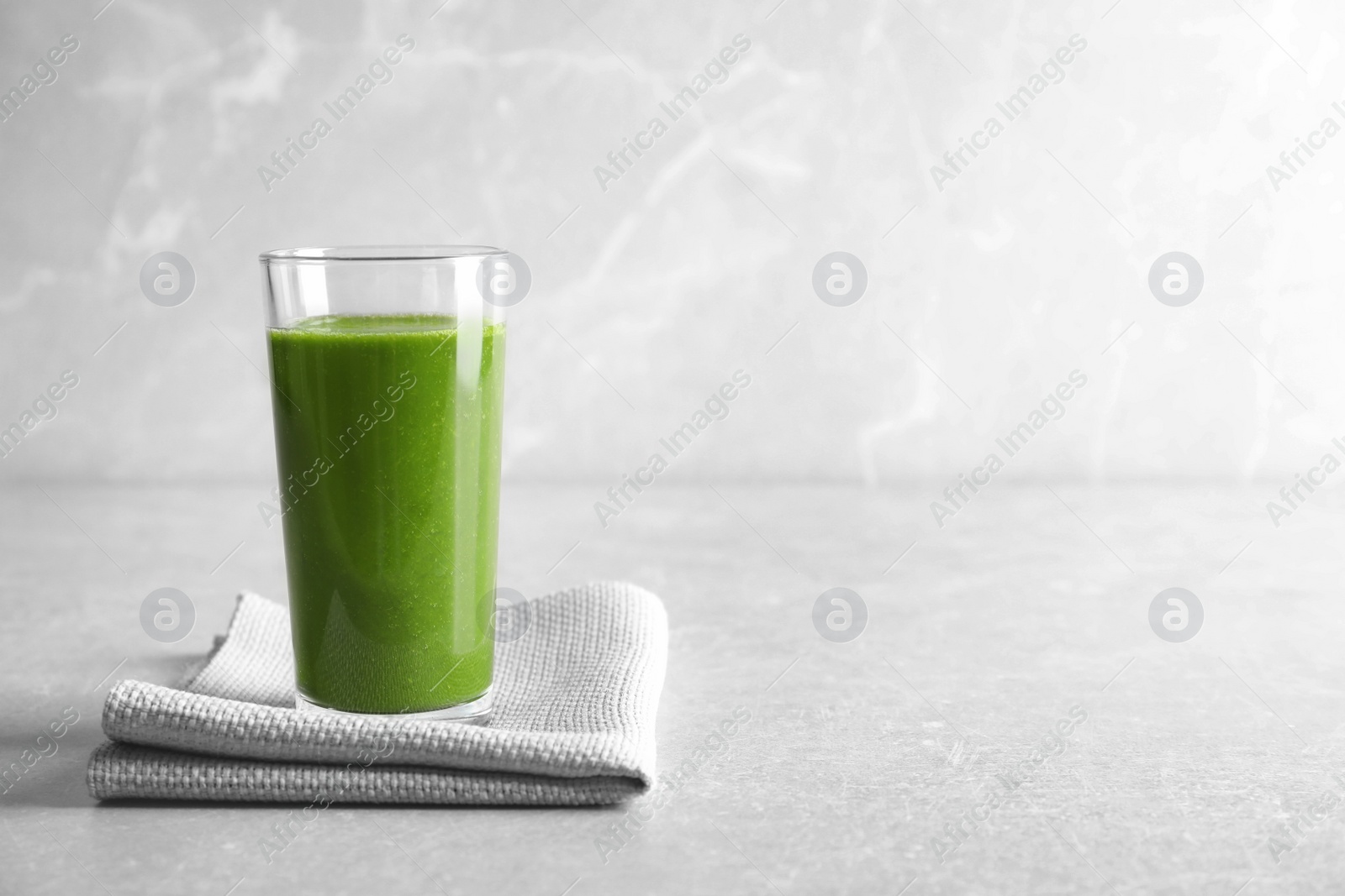 Photo of Glass with delicious detox juice on table