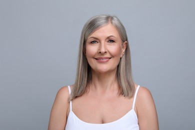 Portrait of beautiful senior woman on grey background