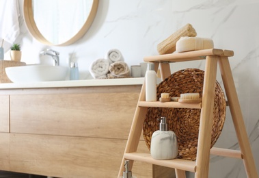 Dispensers and different toiletries on decorative ladder in bathroom. Idea for interior design