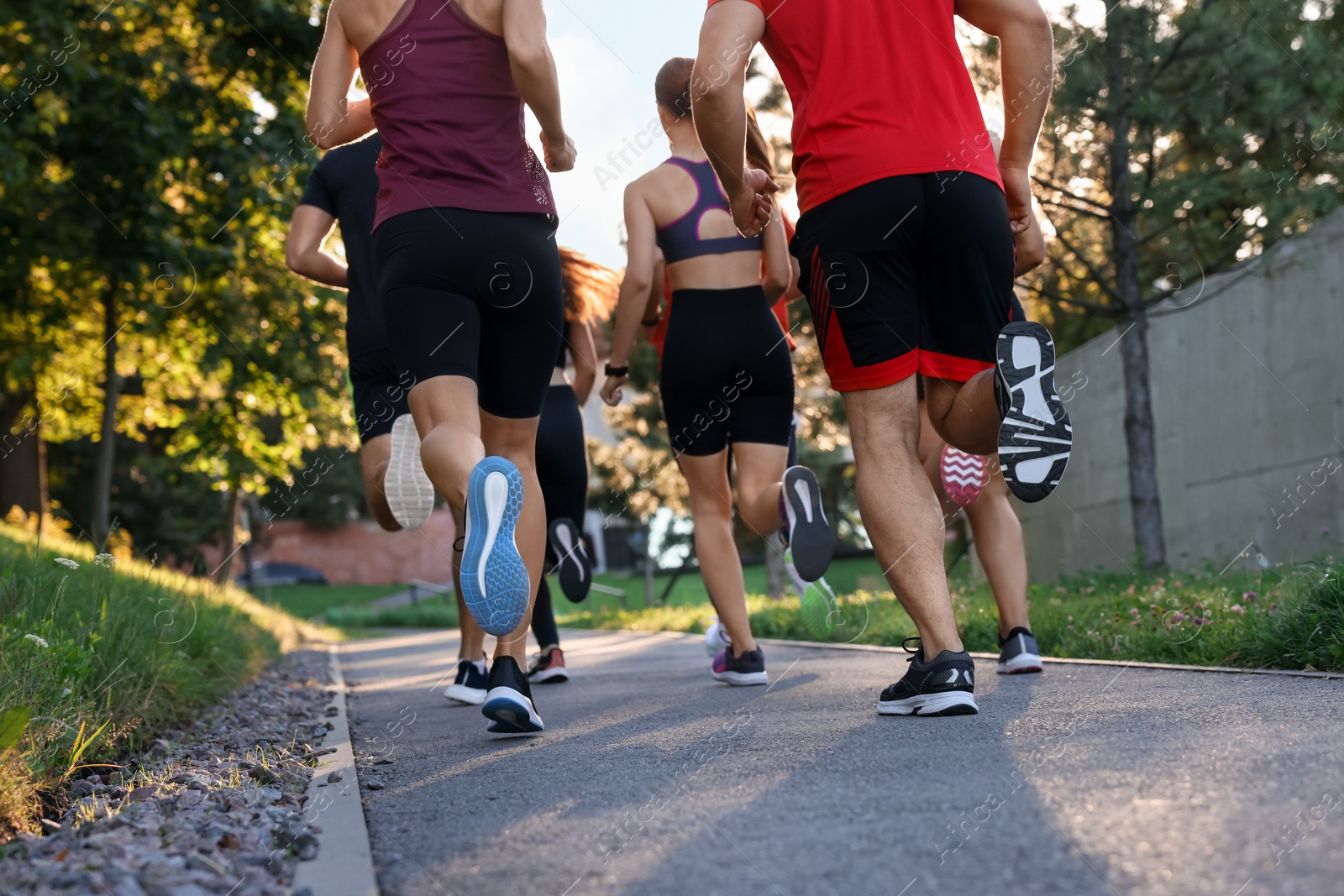 Photo of Group of people running outdoors, back view