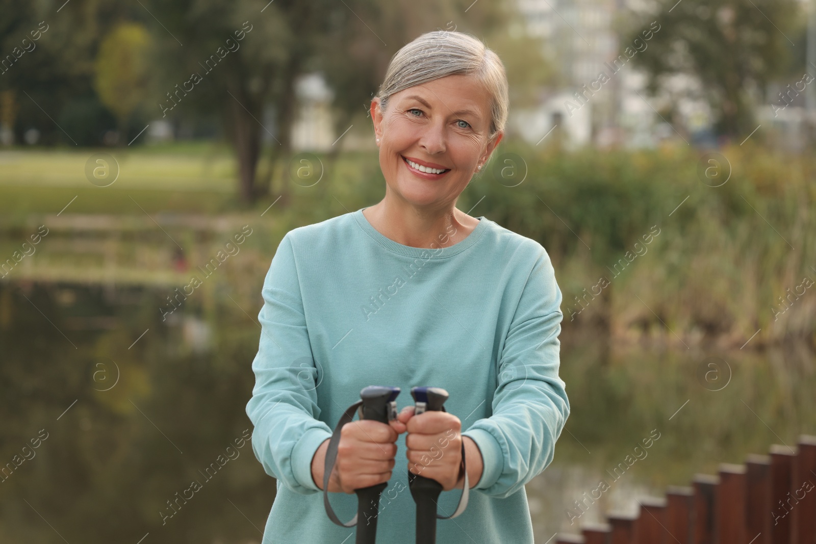 Photo of Senior woman with Nordic walking poles outdoors