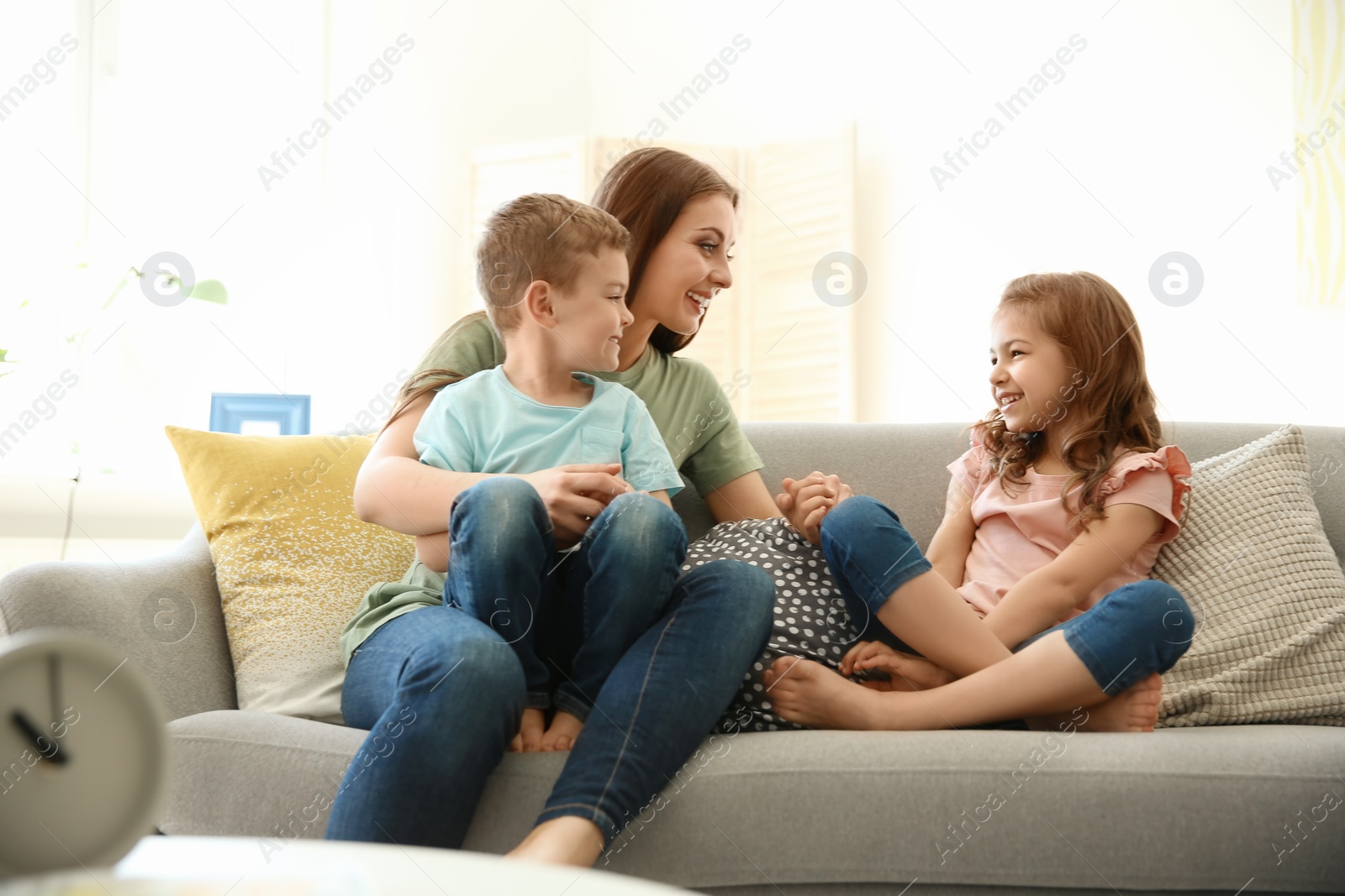 Photo of Young woman spending time with her children at home. Happy family