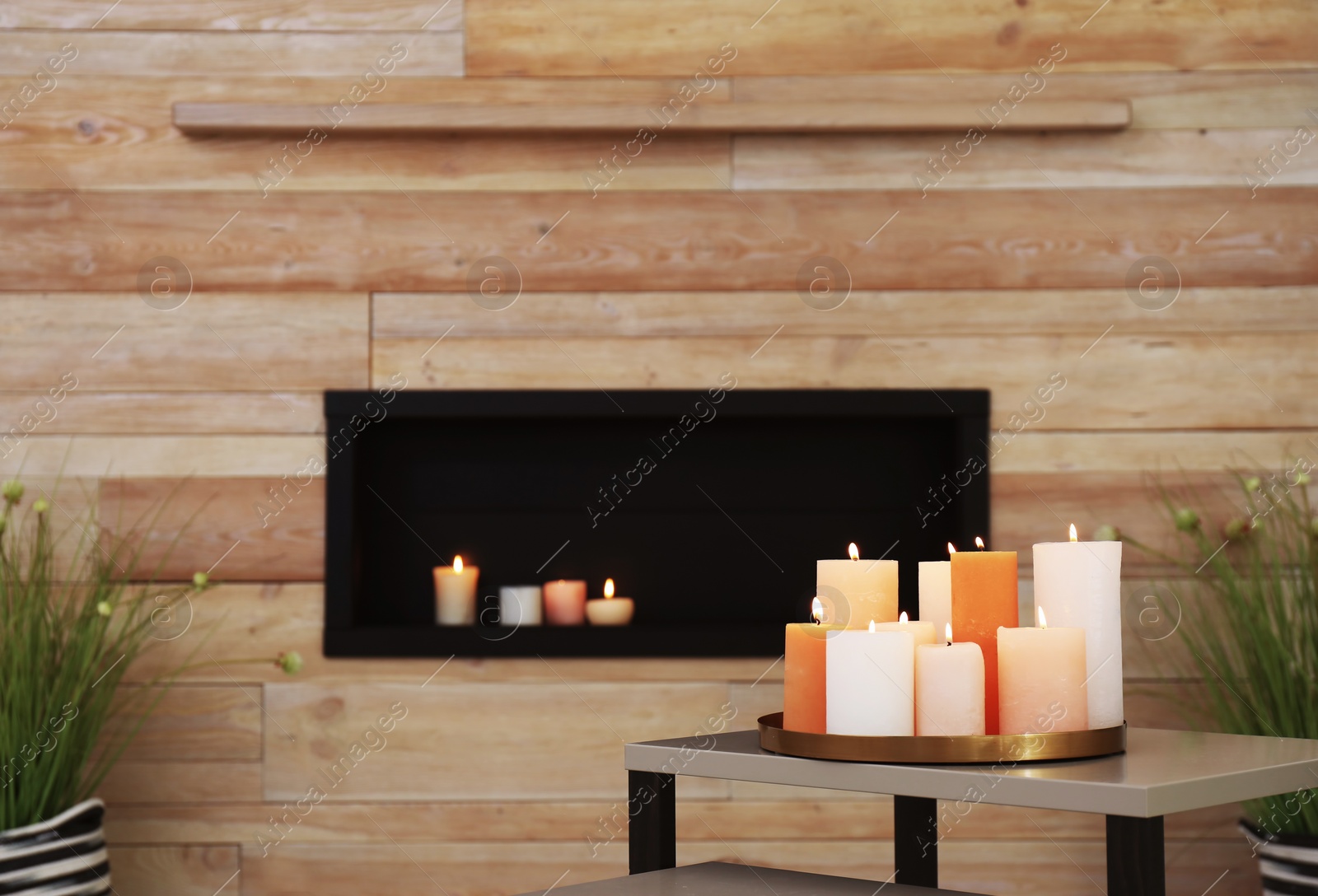 Photo of Tray with burning candles on table in living room