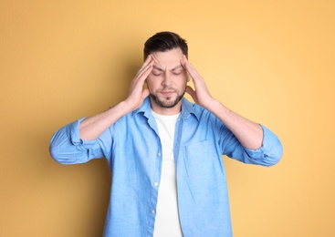 Photo of Man suffering from headache on color background