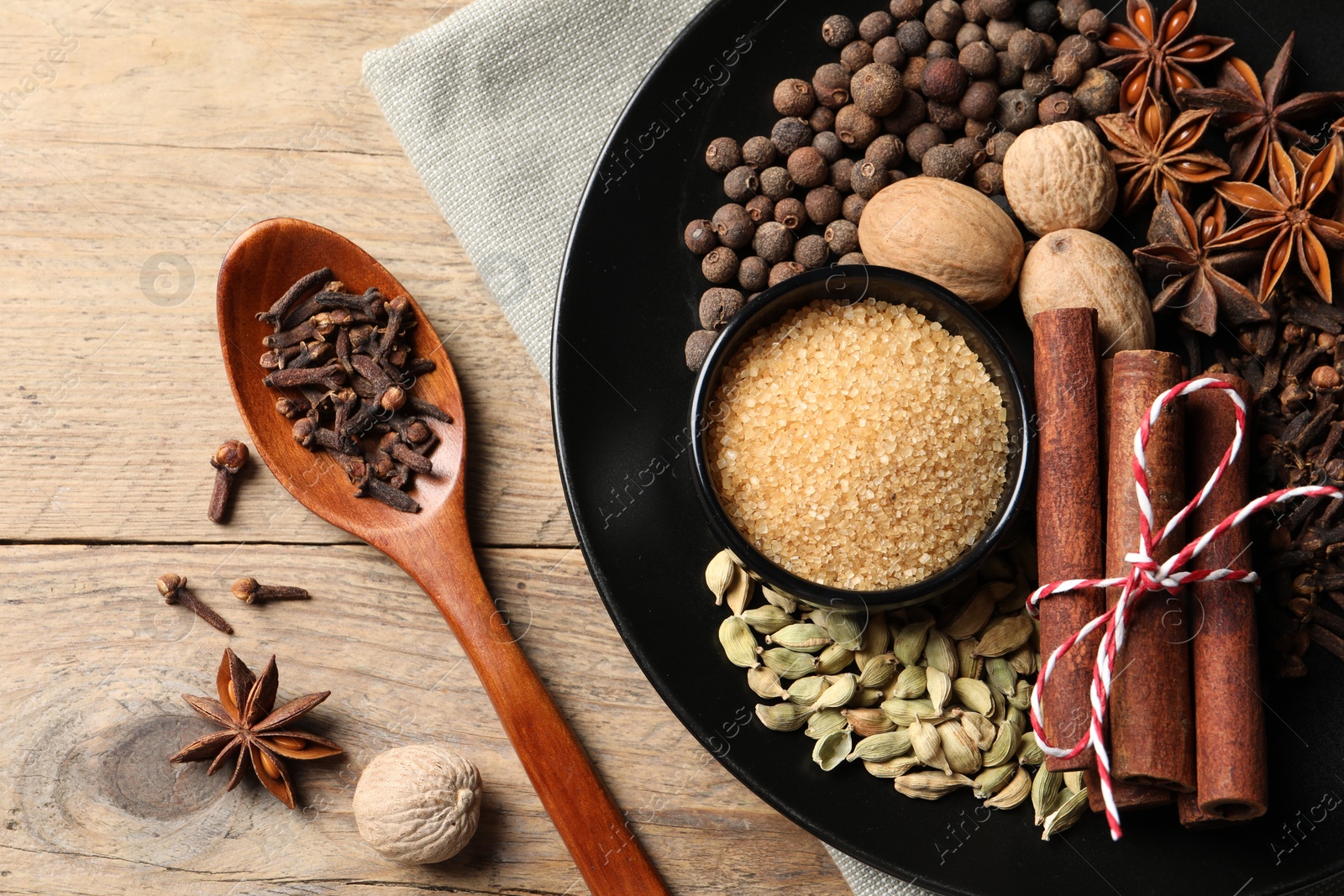 Photo of Dishware with different spices on wooden table, flat lay