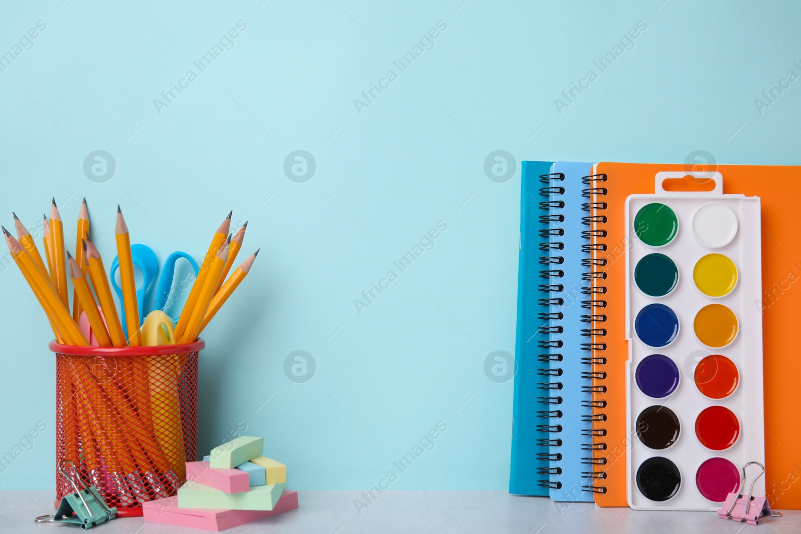 Photo of Different school stationery on table against light blue background, space for text. Back to school