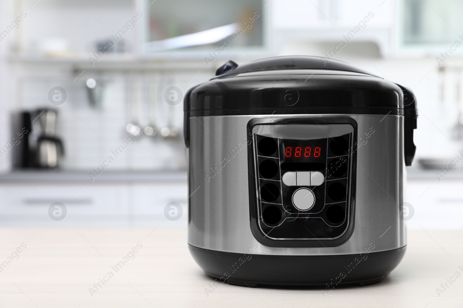 Photo of Modern multi cooker on table in kitchen. Space for text