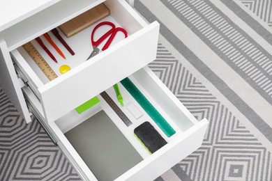 Office supplies in open desk drawers indoors, space for text
