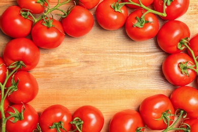 Photo of Frame made of ripe tomatoes on wooden background