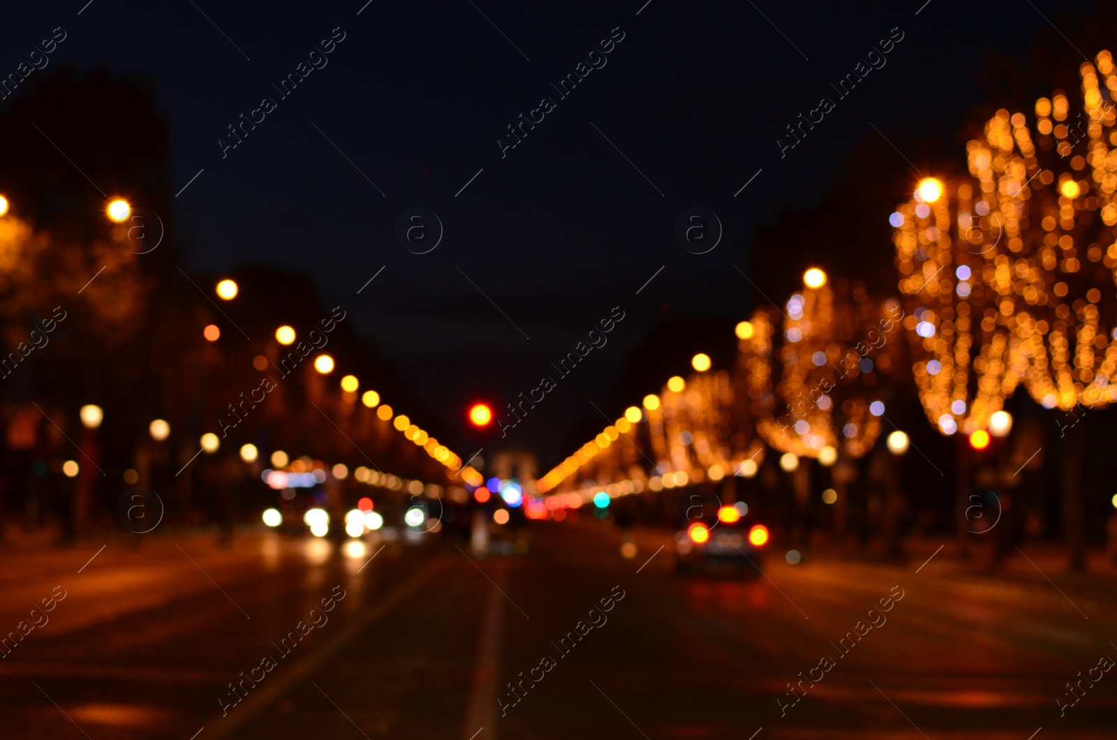 Photo of Blurred view of street with beautiful lights on trees and cars at night. Bokeh effect