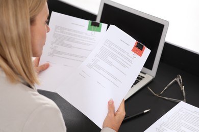 Businesswoman working with documents at dark table in office, closeup