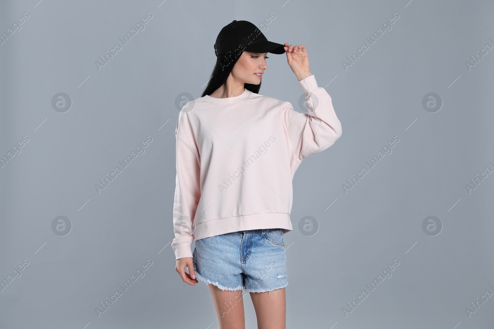 Photo of Portrait of young woman in sweater on grey background. Mock up for design