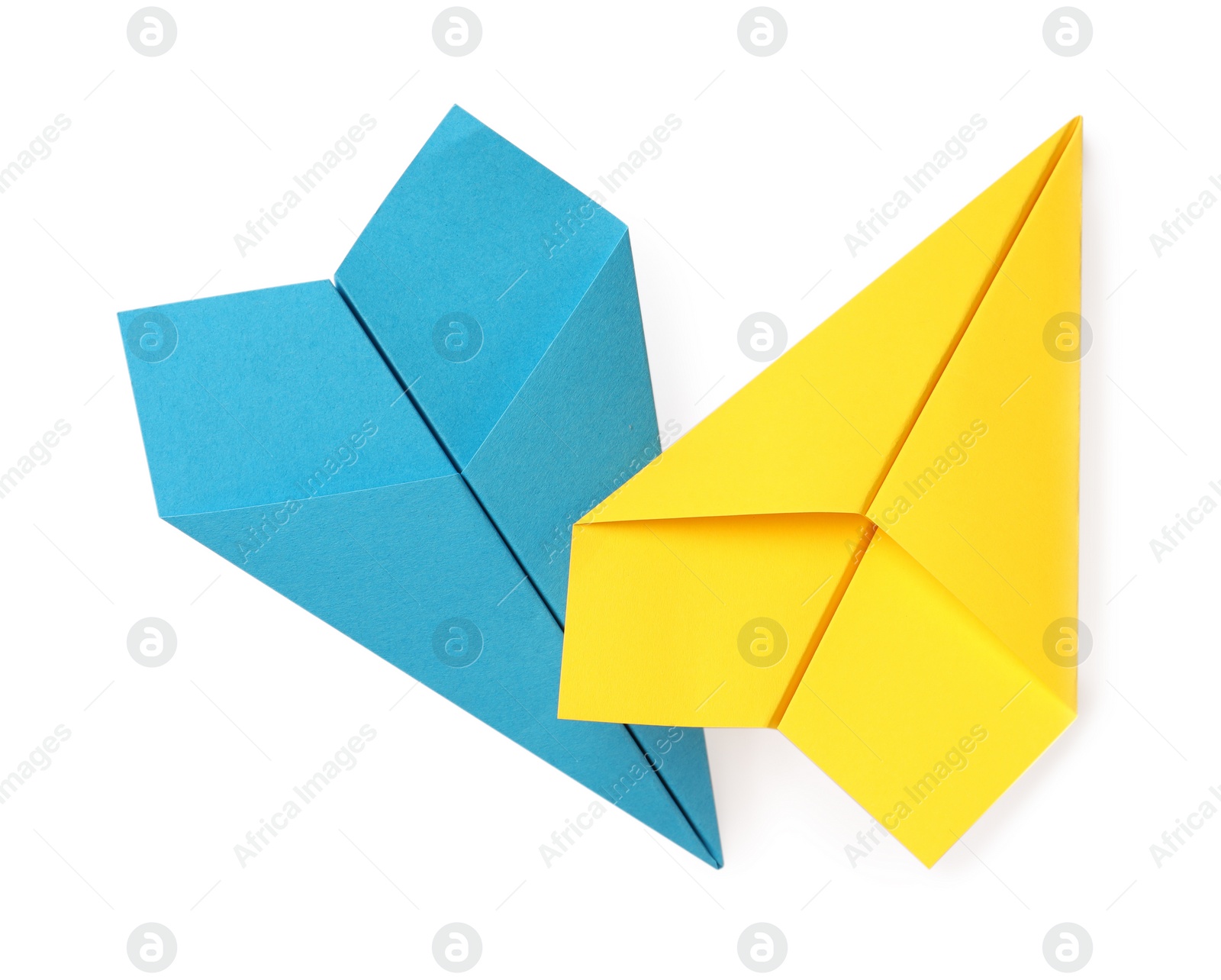 Photo of Handmade light blue and yellow paper planes isolated on white, top view