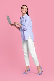 Photo of Happy woman with laptop on pink background