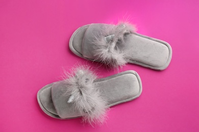 Pair of stylish soft slippers on pink background, flat lay