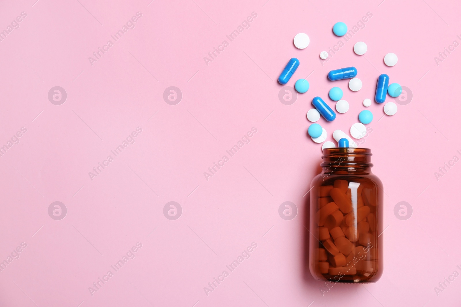 Photo of Bottle with pills on color background