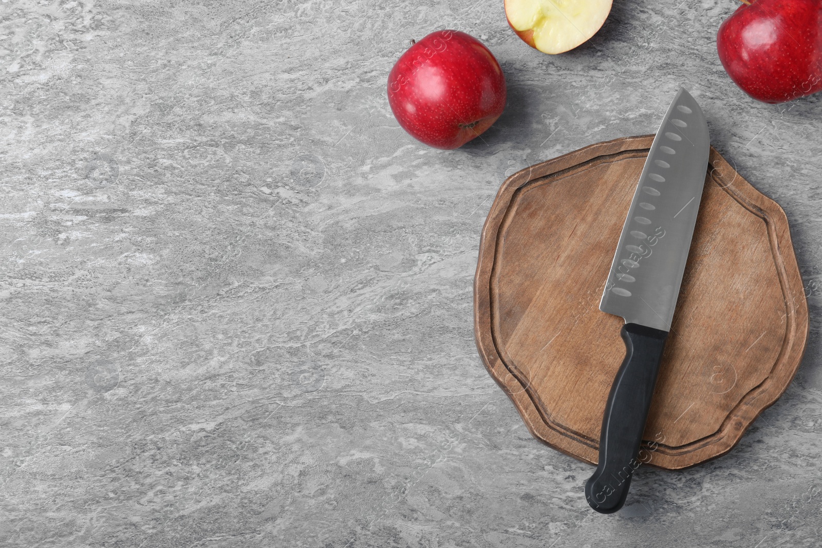 Photo of Flat lay composition with chef's knife and apples on grey background. Space for text