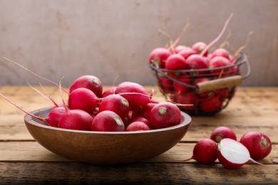 Photo of Bowl with fresh ripe radishes on wooden table