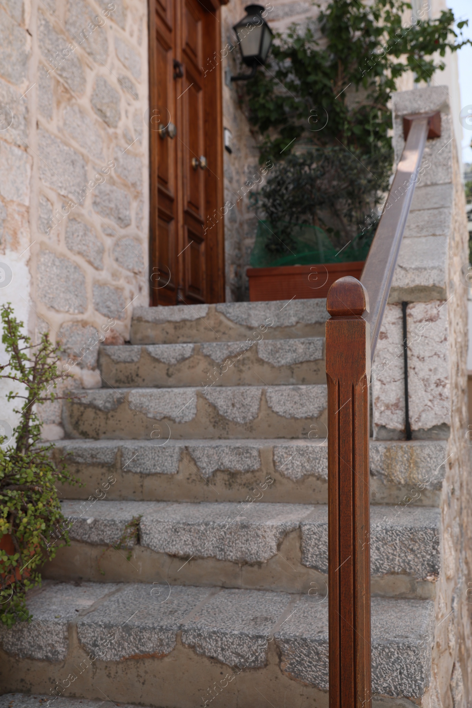 Photo of Beautiful stone stairs with wooden railing near building