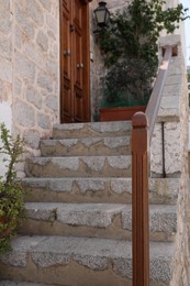 Photo of Beautiful stone stairs with wooden railing near building