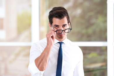 Handsome young man in stylish clothes with glasses indoors