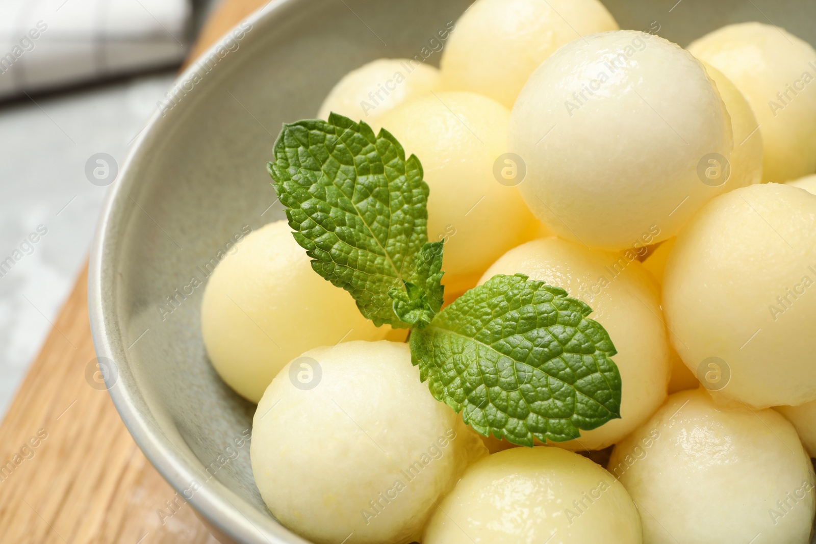 Photo of Melon balls with mint in bowl, closeup