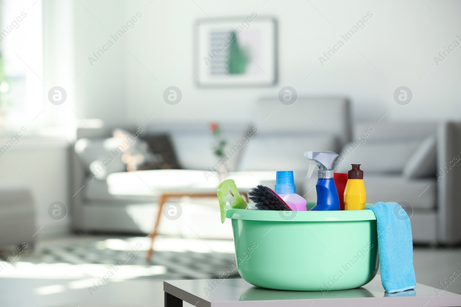 Photo of Basin with cleaning supplies on table indoors