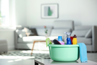 Basin with cleaning supplies on table indoors